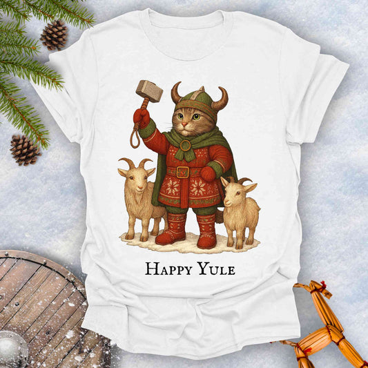 White t-shirt with a Thor lookalike cat in Viking costume, with goats and a hammer, text 'Happy Yule', on a snowy background.