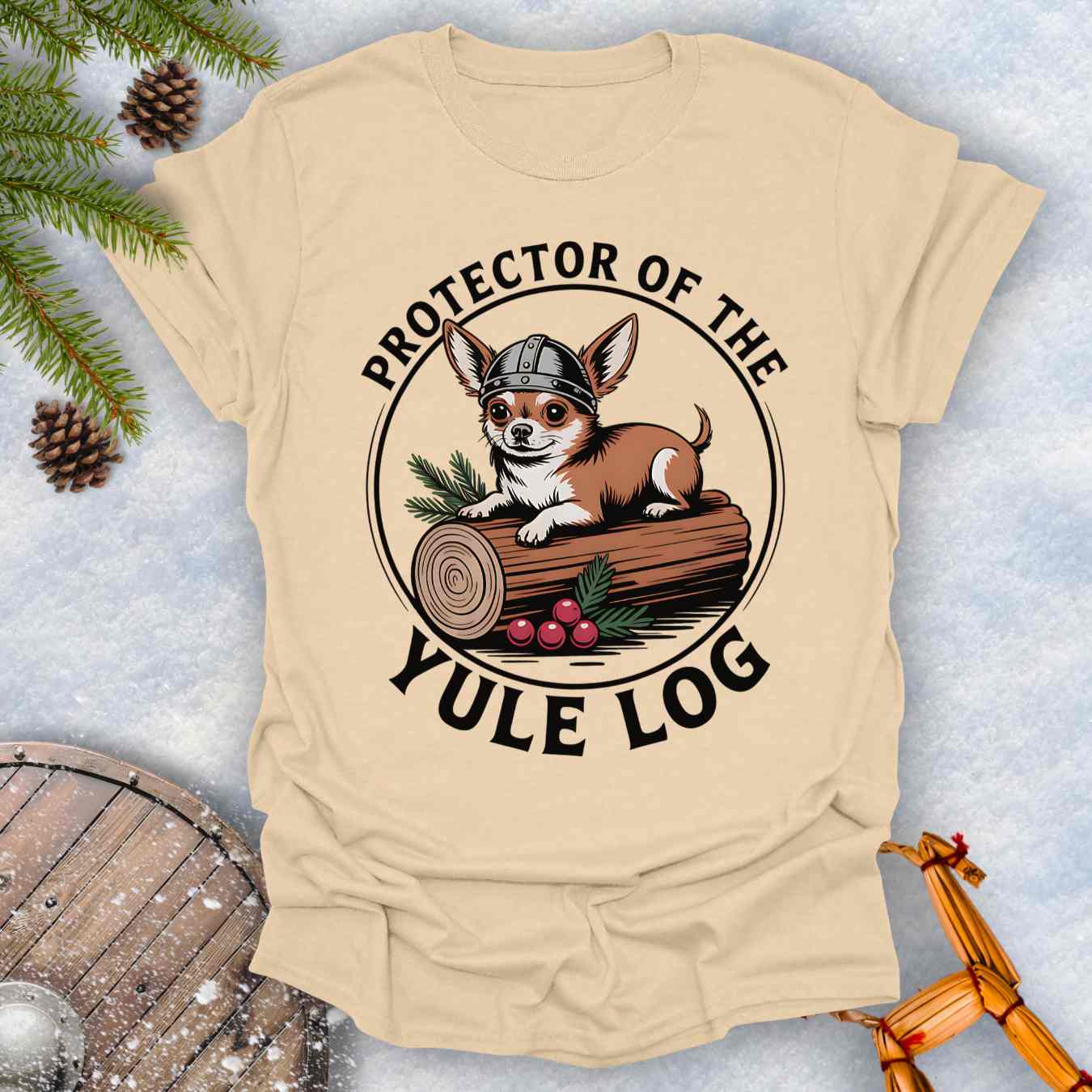 Beige T-shirt with a Chihuahua Viking dog graphic and 'Protector of the Yule Log' text on a snowy background.