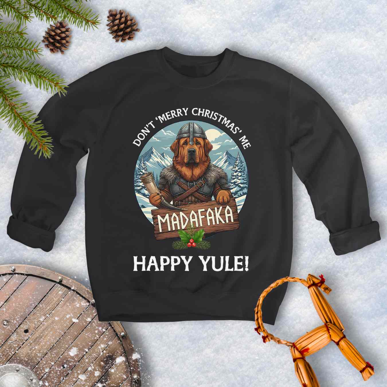 Black sweatshirt with a Viking Tibetan Mastiff holding a sign that says MADAFAKA. Also text: Don´t Merry Christmas Me, Happy Yule! Snowy Mountains and trees in the background.