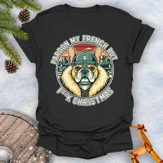 Black t-shirt with a graphic of a Viking French bulldog wearing a helmet and Norse winter retro sunset in the background. Text "Pardon My French but F**K Christmas".