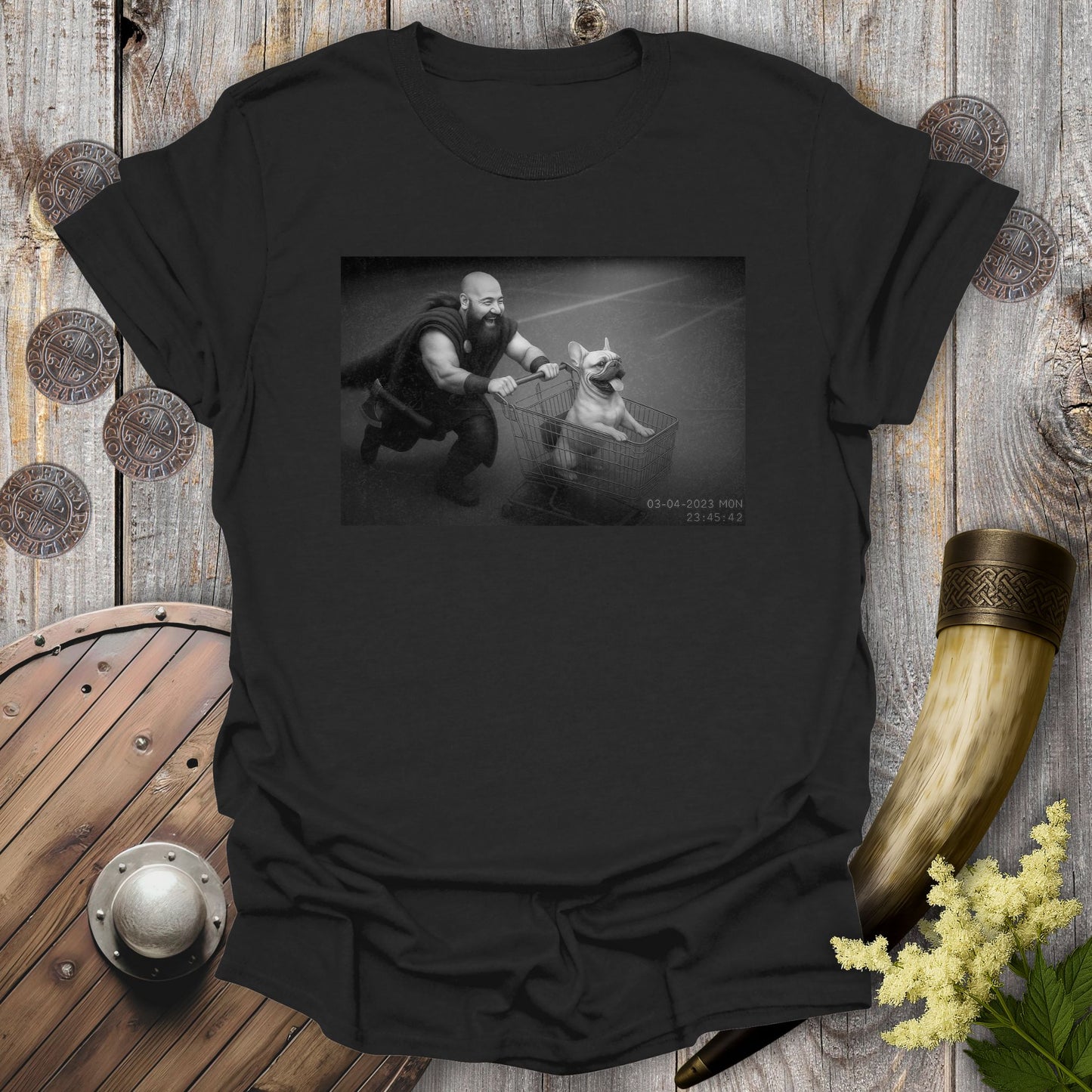 Black t-shirt with a graphic of a Viking and a Bulldog in a shopping cart, sprinting on a parking Lot.