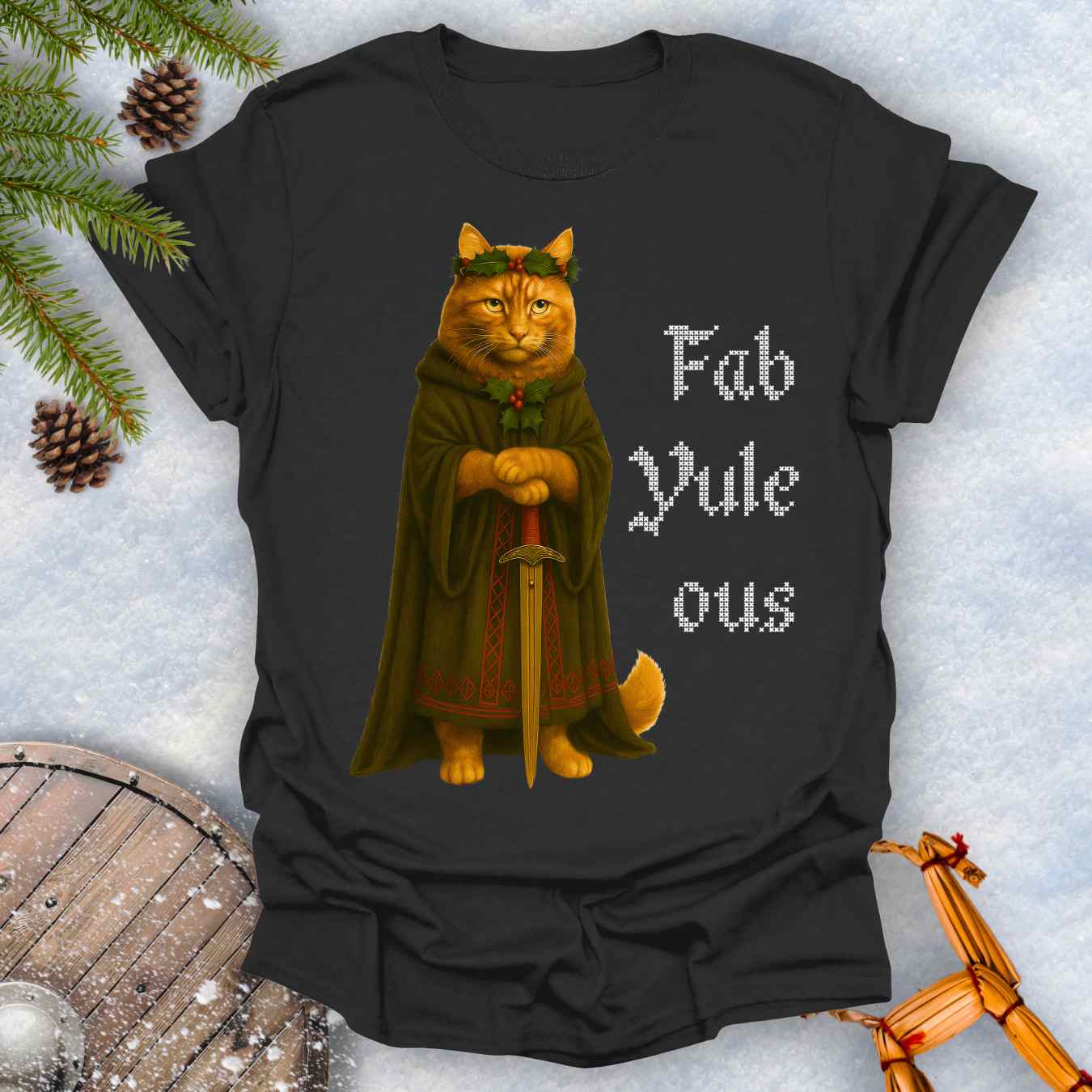 Black t-shirt with a Shieldmaiden cat in a cloak and sword graphic and 'Fab Yule ous' cross stich lookalike text.