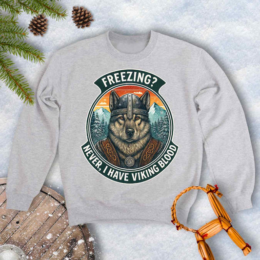 Gray Ash colored sweatshirt with a graphic of a Viking Norwegian Elkhound and text 'Freezing? Never, I have Viking blood' with a Nordic, retro sunset graphic in the background.