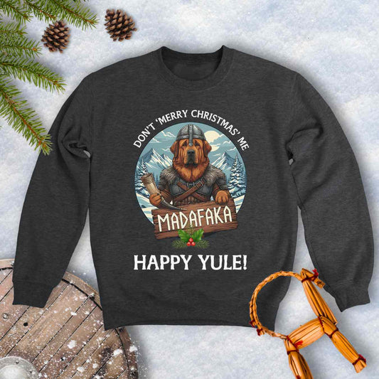 Gray sweatshirt with a Viking Tibetan Mastiff holding a sign that says MADAFAKA. Also text: Don´t Merry Christmas Me, Happy Yule! Snowy Mountains and trees in the background.