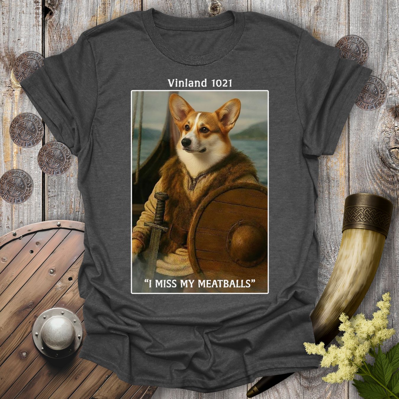 Gray Dark heather colored t-shirt with a graphic of a Corgi Viking dog as Leif Erikson in a longship with text "Vinland 1021" and "I Miss My Meatballs".