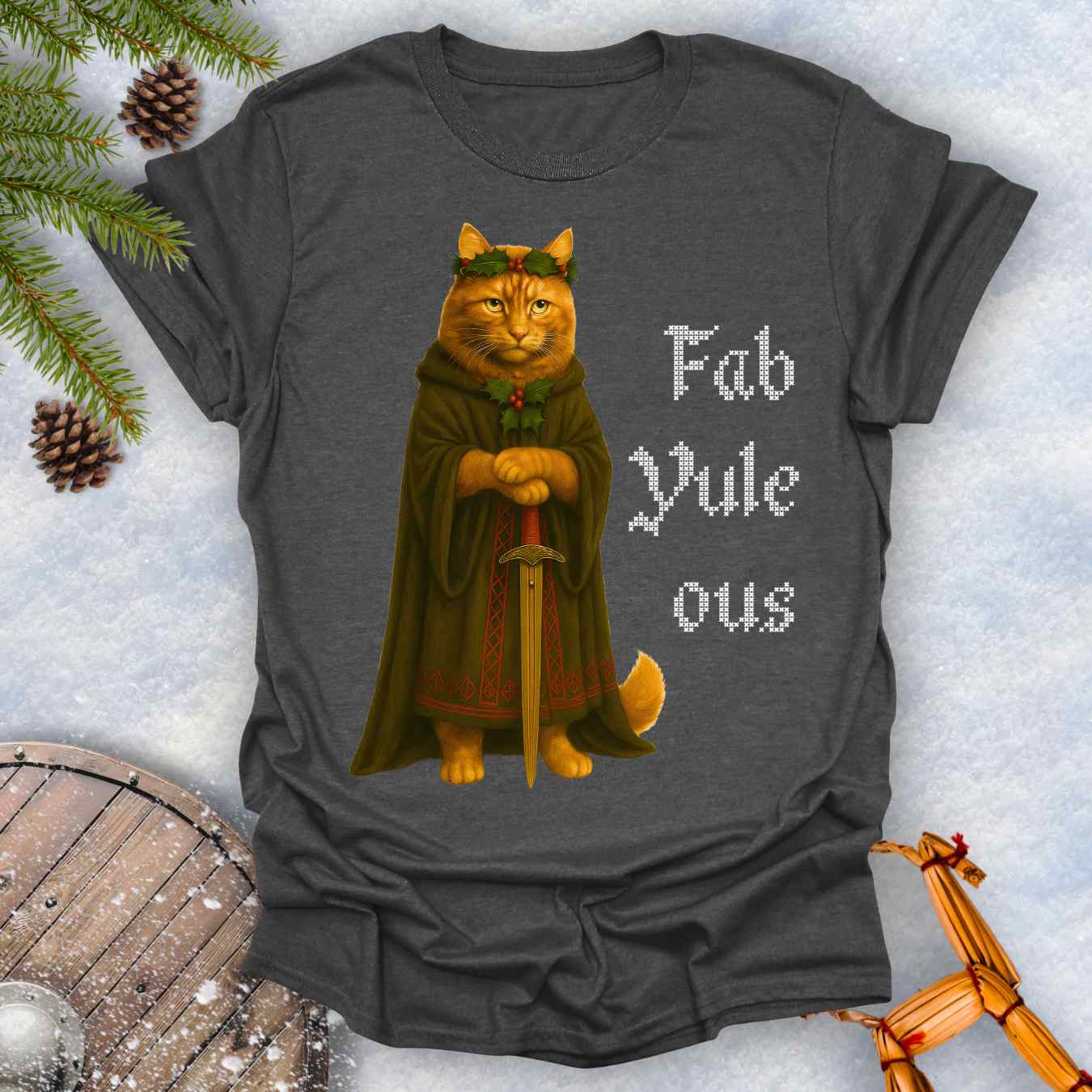 Gray dark heater colored t-shirt with a Shieldmaiden cat in a cloak and sword graphic and 'Fab Yule ous' cross stich lookalike text.