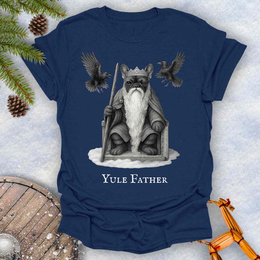 Navy Blue T-shirt with 'Yule Father' design featuring a French bulldog dog as the aesir Odin, with a beard and a crown, surrounded by two ravens on a snowy background.