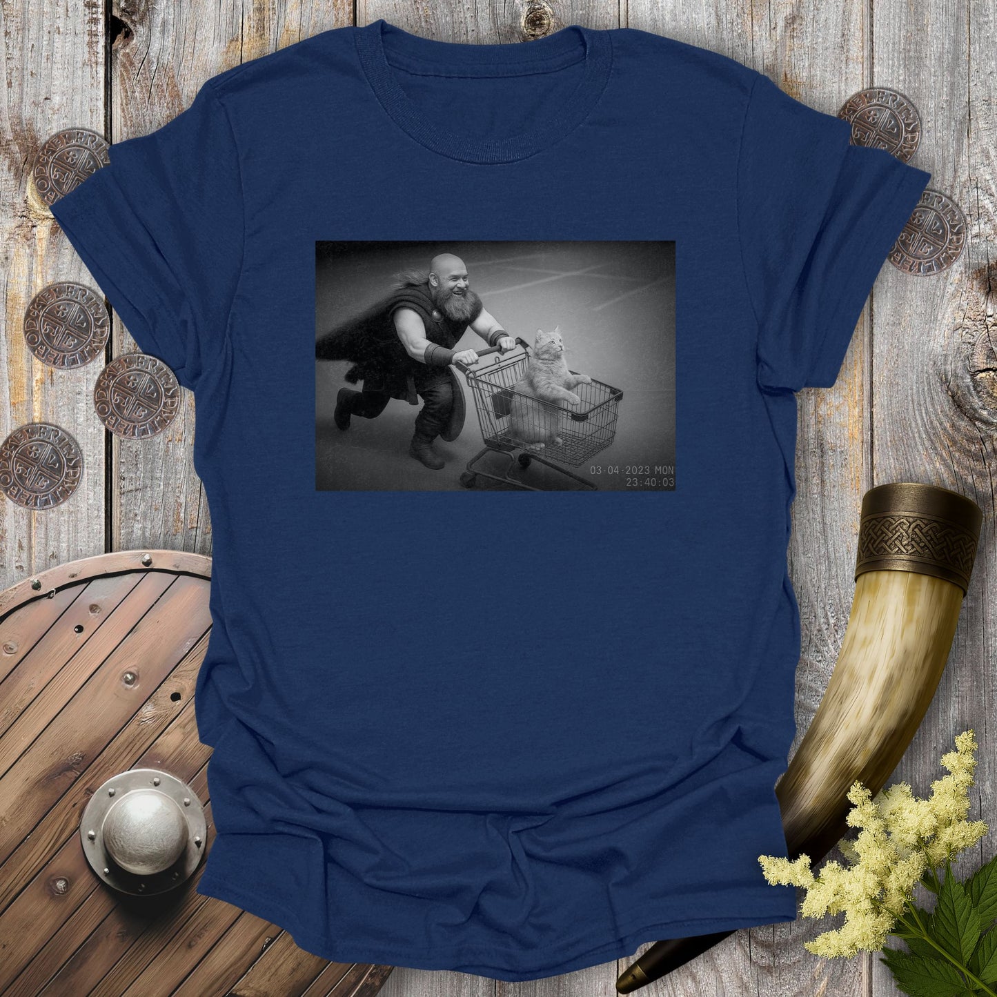 Navy Blue t-shirt with a graphic of a Viking and a cat in a shopping cart, sprinting on a parking lot.