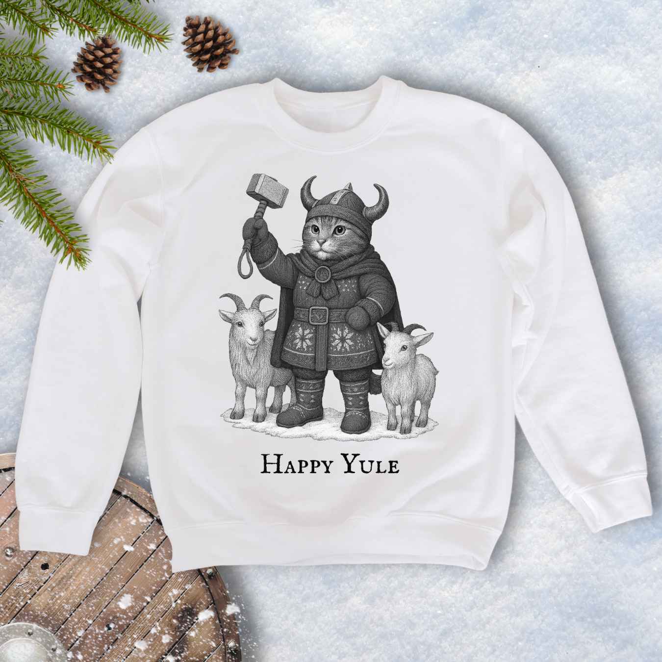 White sweatshirt with a black and white graphic of a Viking cat in winter gear, holding hammer Mjölnir, surrounded by two goats. 'Happy Yule' text under the image.