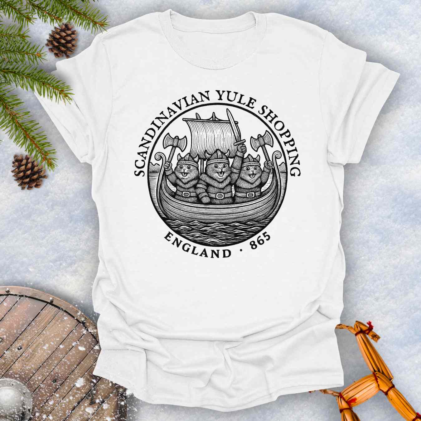 White t-shirt with a black graphic design of Viking cats in a ship. Text: Scandinavian Yule Shopping England 865