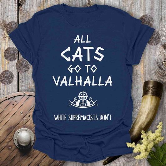 Navy blue t-shirt with white text 'all cats go to Valhalla white supremacists don't' on a wooden background