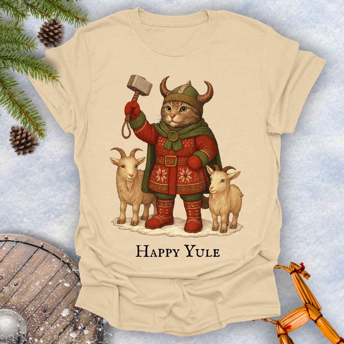 Beige sand t-shirt with a Thor lookalike cat in Viking costume, with goats and a hammer, text 'Happy Yule', on a snowy background.