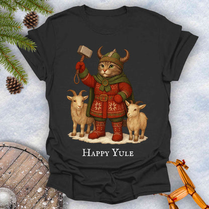 Black t-shirt with a cat in Viking attire holding a hammer, surrounded by goats and 'Happy Yule' text, on a snowy background.