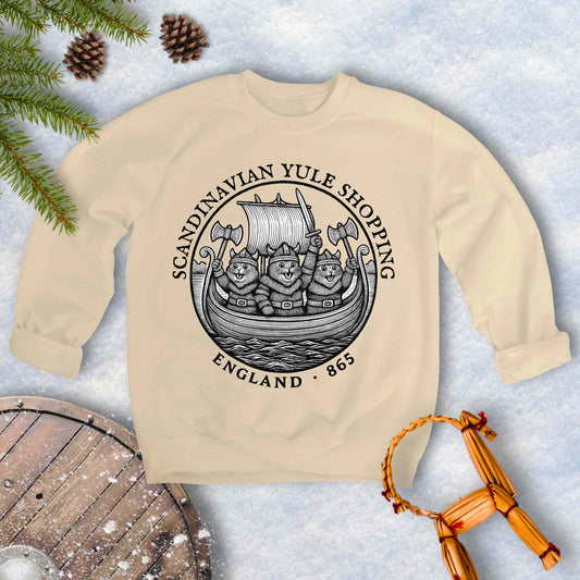 Beige sweatshirt with black and white design with Viking Cats on a Viking ship and text Scandinavian Yule Shopping, England 865.
