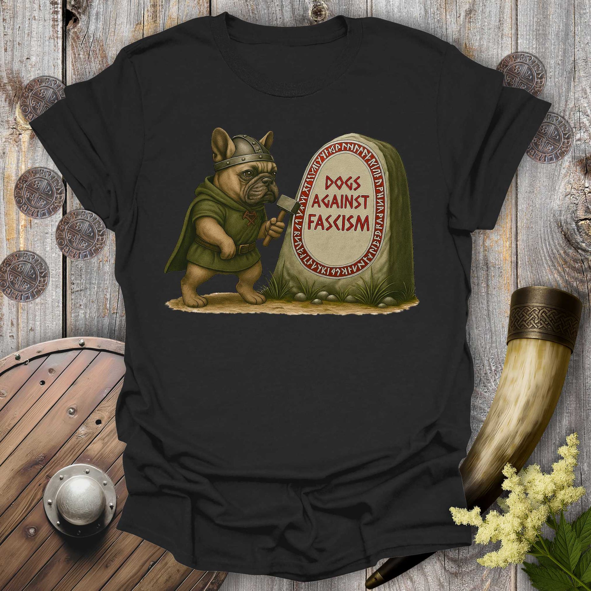 Black Anti-Fascism No Kings t-shirt with a graphic of a Bulldog in Viking attire holding a hammer next to a stone with "Dogs Against Fascism" text, displayed on a wooden surface.