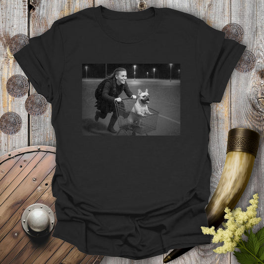 Black t-shirt with a graphic of a Viking Shieldmaiden and a Bulldog in a shopping cart, sprinting on a Parking Lot.