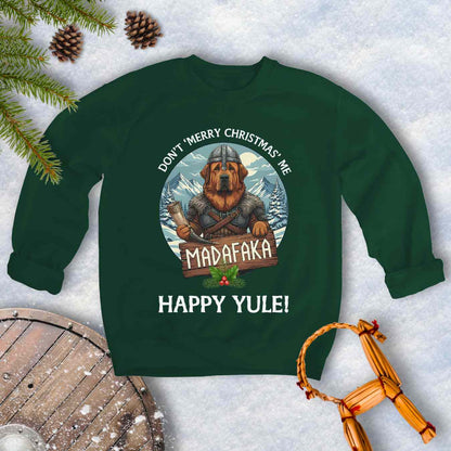 Green sweatshirt with a Viking Tibetan Mastiff holding a sign that says MADAFAKA. Also text: Don´t Merry Christmas Me, Happy Yule! Snowy Mountains and trees in the background.