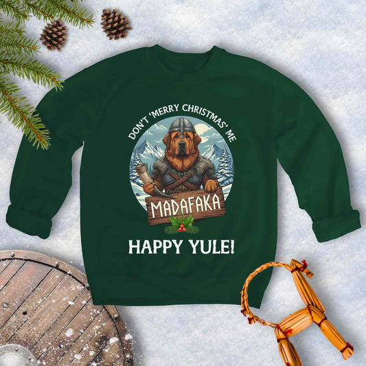 Green sweatshirt with a Viking Tibetan Mastiff holding a sign that says MADAFAKA. Also text: Don´t Merry Christmas Me, Happy Yule! Snowy Mountains and trees in the background.