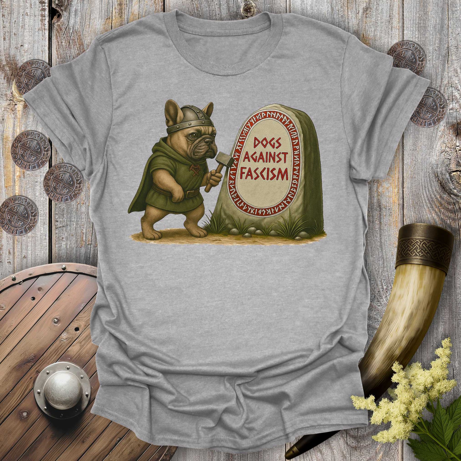 Gray Anti-Fascism No Kings t-shirt with a graphic of a Bulldog in Viking attire holding a hammer next to a stone with "Dogs Against Fascism" text, displayed on a wooden surface.