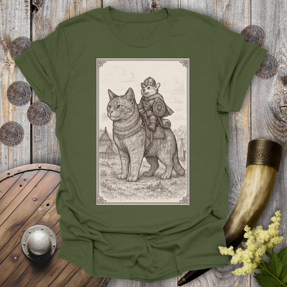 Green t-shirt with a beige and black graphic of a large cat and a Corgi Viking Dog riding it, in a Medieval Viking Age setting. 