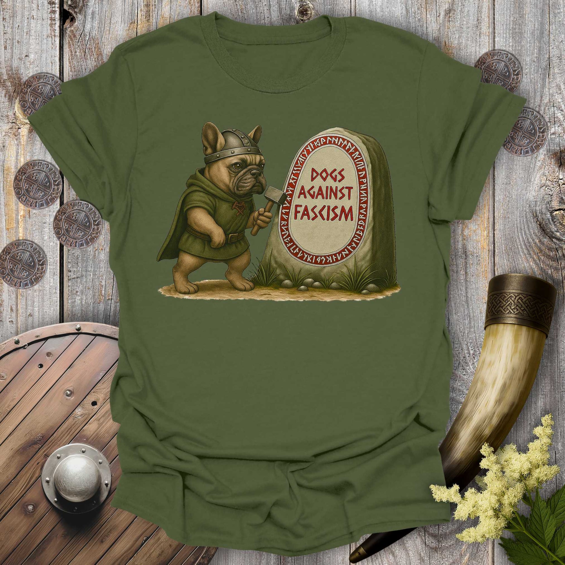 Anti-Fascism No Kings t-shirt with a graphic of a Bulldog in Viking attire holding a hammer next to a stone with "Dogs Against Fascism" text, displayed on a wooden surface.