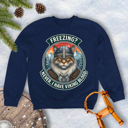 Navy Blue sweatshirt with a graphic of a Viking Norwegian Forest Cat and text 'Freezing? Never, I have Viking blood' with a Nordic, retro sunset graphic in the background.