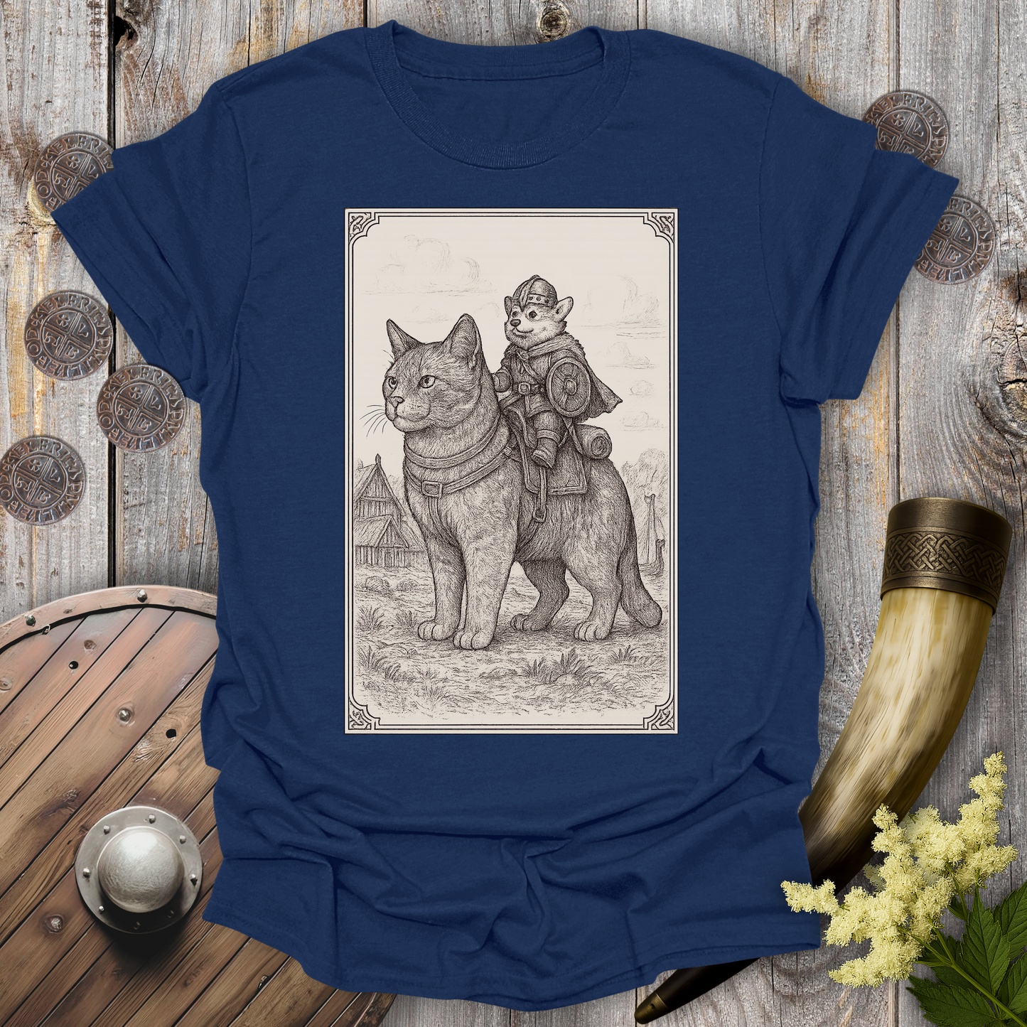 Navy Blue t-shirt with a beige and black graphic of a large cat and a Corgi Viking Dog riding it, in a Medieval Viking Age setting. 