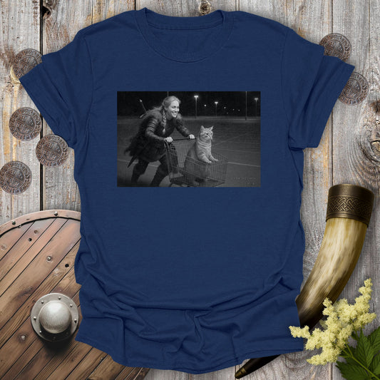 Navy Blue t-shirt with a graphic of a Viking Shieldmaiden and a tabby cat in a shopping cart, sprinting on a parking Lot.