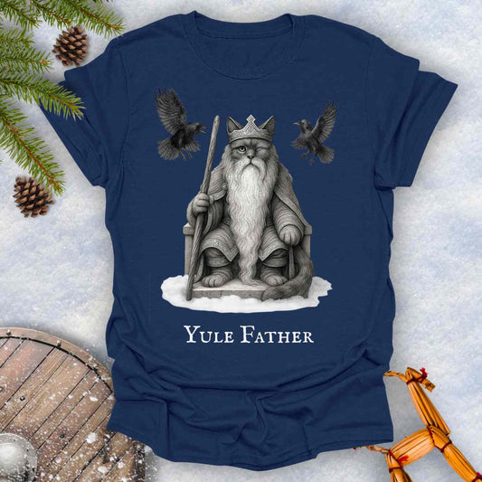 Navy blue T-Shirt with the aesir Odin reimagined as a black cat. Text 'Yule Father' design on a snowy background.