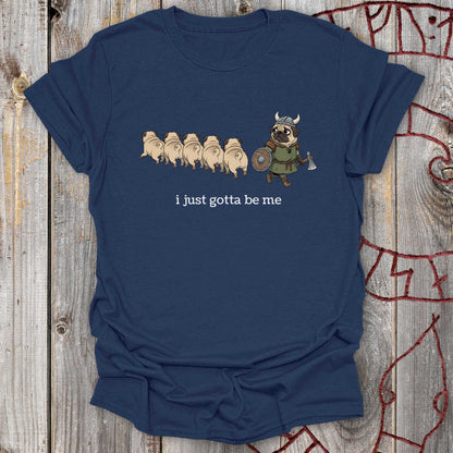 Navy blue t-shirt with cartoon design with a Viking Pug and text 'I just gotta be me' on a wooden surface
