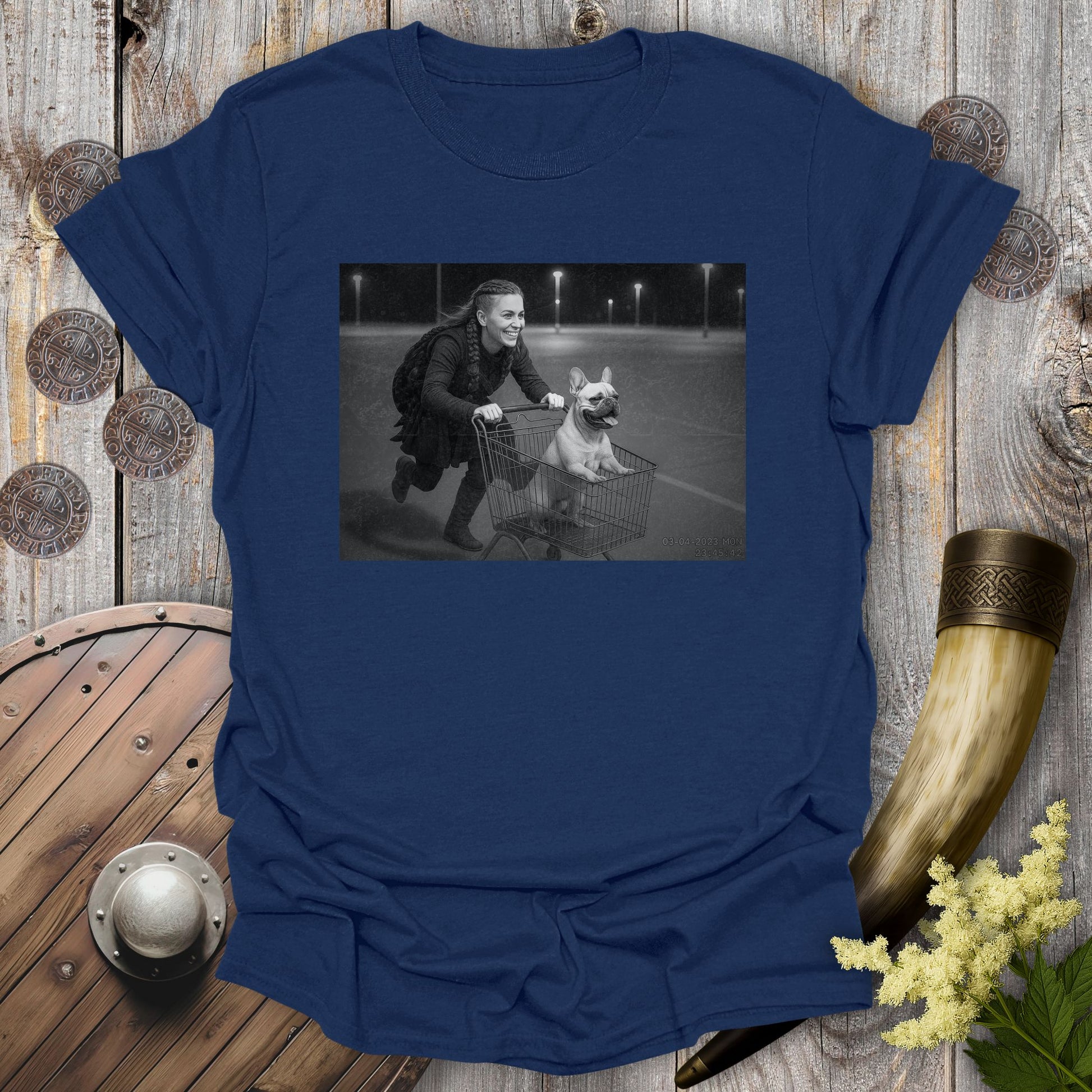 Navy Blue t-shirt with a graphic of a Viking Shieldmaiden and a Bulldog in a shopping cart, sprinting on a parking Lot.