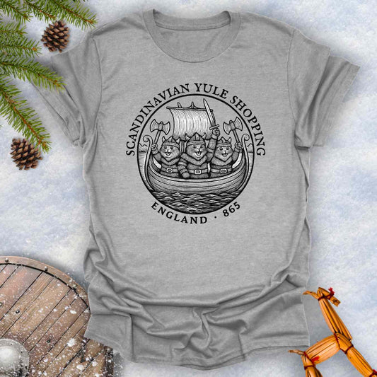 Gray t-shirt with a black graphic design of Viking cats in a ship. Text: Scandinavian Yule Shopping England 865