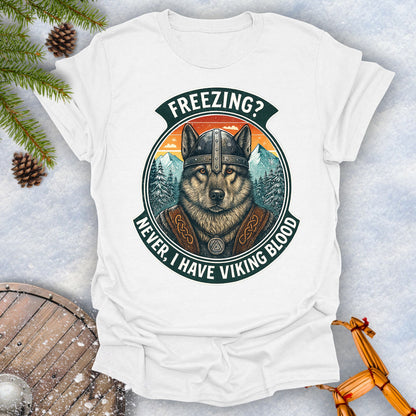 White t-shirt with a graphic of a Viking Norwegian Elkhound and text 'Freezing? Never, I have Viking blood' with a Nordic, retro sunset graphic in the background.
