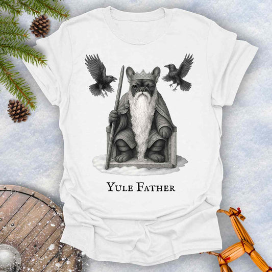White t-shirt with 'Yule Father' design featuring a French bulldog dog as the aesir Odin, with a beard and a crown, surrounded by two ravens on a snowy background.
