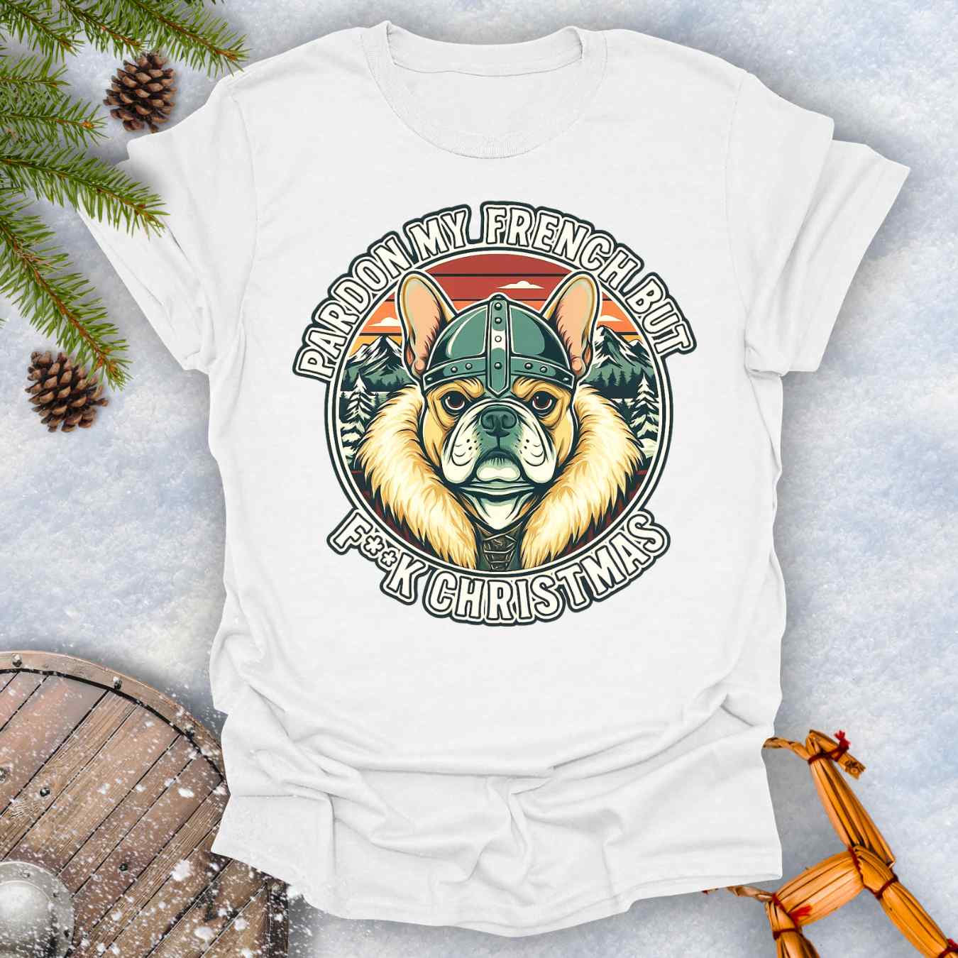 White t-shirt with a graphic of a Viking French bulldog wearing a helmet and Norse winter retro sunset in the background. Text "Pardon My French but F**K Christmas".