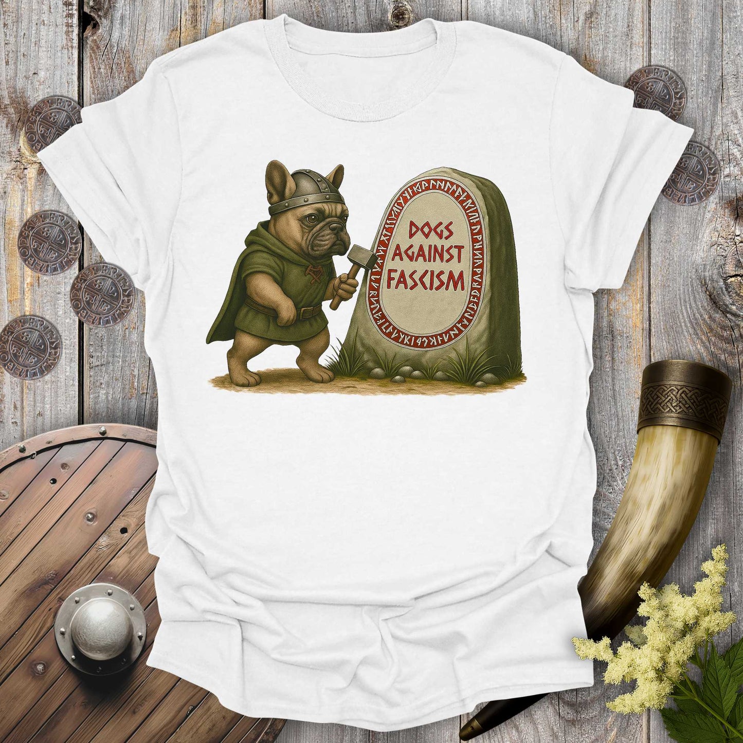 White Anti-Fascism No Kings t-shirt with a graphic of a Bulldog in Viking attire holding a hammer next to a stone with "Dogs Against Fascism" text, displayed on a wooden surface.