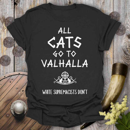 Black t-shirt with 'All cats go to Valhalla, white supremacists don't' text on a wooden background.