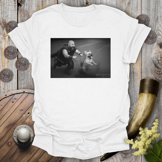White t-shirt with a graphic of a Viking and a Bulldog in a shopping cart, sprinting on a parking Lot.